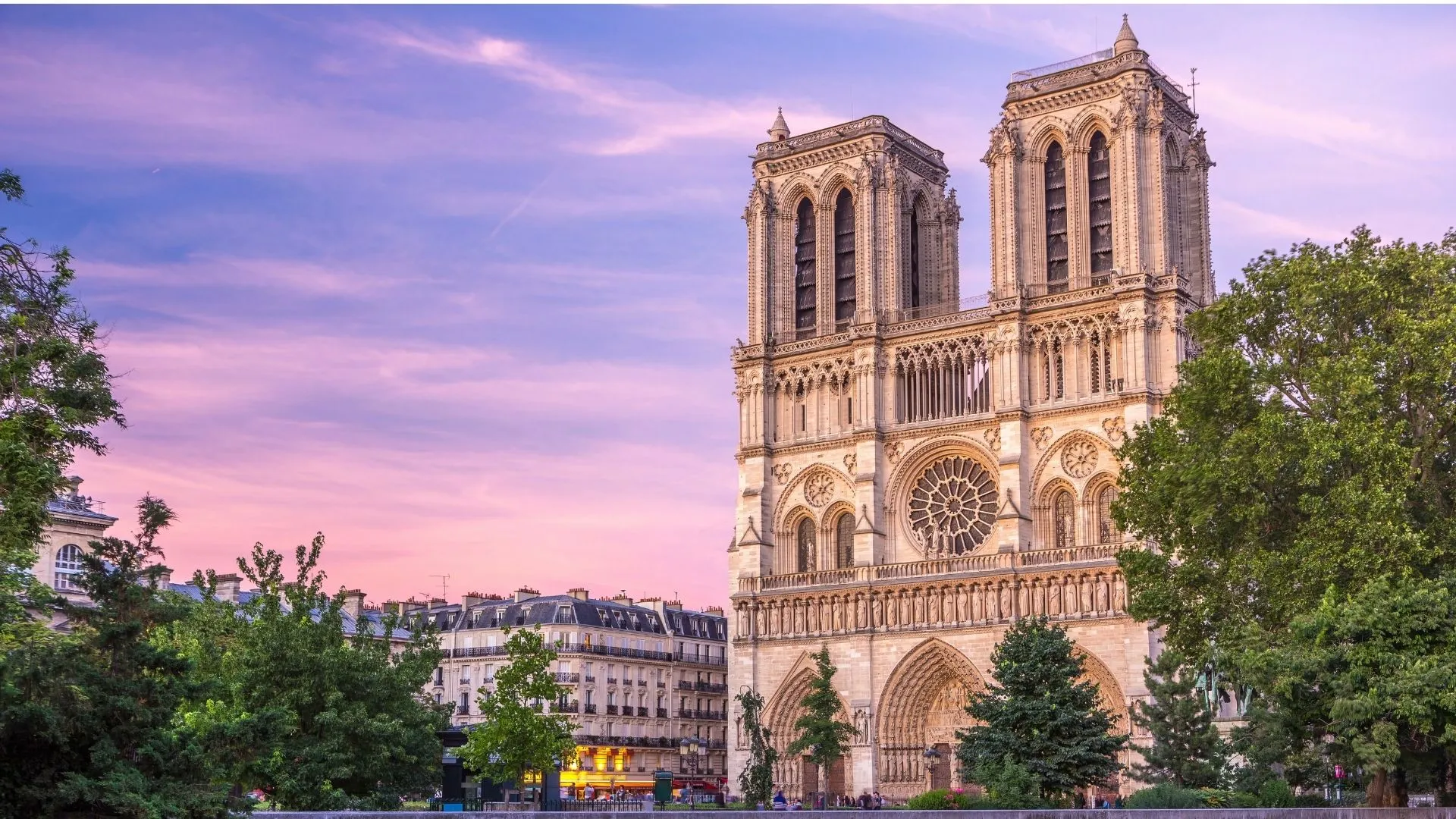 Cathédrale Notre-Dame de Paris au coucher du soleil, façade gothique avec rosace et deux tours, monument médiéval français rouvert en décembre 2024